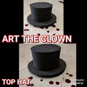 May include: A black top hat with a wide brim, sitting on a white surface with red splatters. The text "ART THE CLOWN" is above the hat and "TOP HAT" is below the hat.