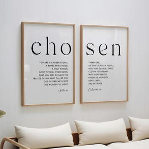 Könnte beinhalten: Zwei gerahmte Kunstdrucke mit dem Wort "auserwählt" in großen schwarzen Buchstaben. Die Drucke zeigen inspirierenden Text in einem minimalistischen Stil. Die Rahmen sind aus hellem Holz, der Hintergrund ist weiß.