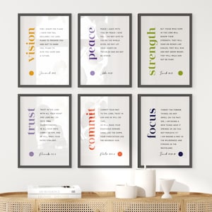 May include: Six framed art prints with inspirational quotes. The prints feature words like "vision," "peace," and "strength" in various colors. The frames are black, and the prints are displayed on a wooden cabinet with decorative items.