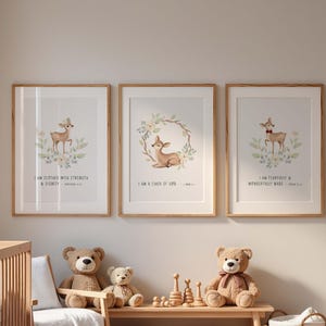 Könnte beinhalten: Drei gerahmte Drucke mit Aquarell-Hirsch-Illustrationen und inspirierenden Zitaten. Die Drucke befinden sich in einem Kinderzimmer, mit einem Holzbett, Teddybären und einer Bank mit Spielzeug. Der Text auf den Drucken lautet: "I AM CLOTHED WITH STRENGTH & DIGNITY", "I AM A CHILD OF GOD" und "I AM FEARFULLY & WONDERFULLY MADE".