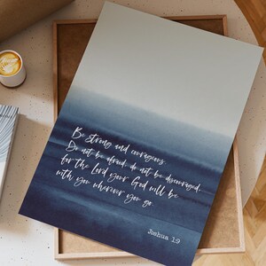 May include: A blue and white watercolor print with a quote from Joshua 1:9, "Be strong and courageous. Do not be afraid; do not be discouraged, for the Lord your God will be with you wherever you go."