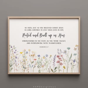 Könnte beinhalten: Gerahmter Druck mit dem Text "Rooted and Built up in Him" und einem floralen Rand. Der Text ist schwarz, mit einem hellbeigen Hintergrund. Der florale Rand zeigt bunte Wildblumen. Der Rahmen ist hellbraun.
