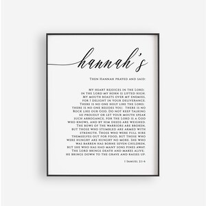 K&ouml;nnte beinhalten: Schwarz-wei&szlig;es druckbares Wandbild mit dem Namen "Hannah's" in Kursivschrift. Der Text enth&auml;lt einen Bibelvers aus 1 Samuel 2,1-6 &uuml;ber Hannahs Dankgebet.