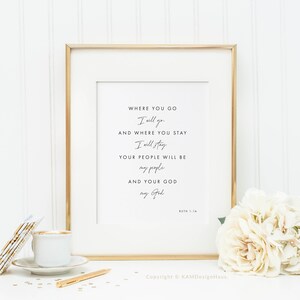May include: A framed print with a gold frame and a white background. The print features a quote from the Bible, Ruth 1:16, which reads: "Where you go I will go, and where you stay I will stay. Your people will be my people and your God my God."