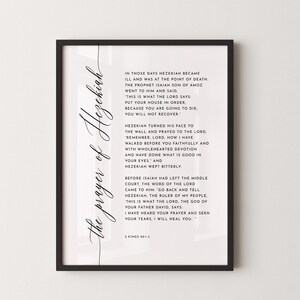 May include: A framed print with the text "the prayer of Hezekiah" in elegant script. The print features a passage from 2 Kings 20:1-5, printed in black on a white background. The frame is black.