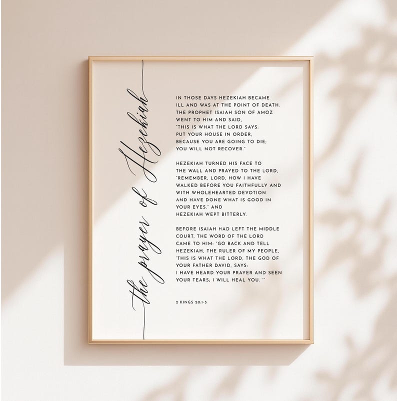 May include: A framed print with the title "The prayer of Hezekiah" in elegant script. The print features a passage from 2 Kings 20:1-5, with text in a classic serif font. The frame is a warm gold color.