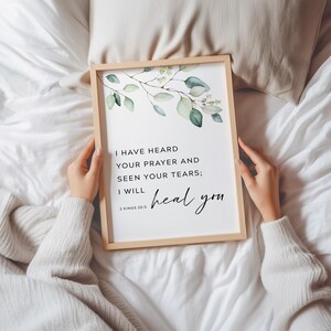 May include: A framed print with a watercolor illustration of green leaves and the text "I HAVE HEARD YOUR PRAYER AND SEEN YOUR TEARS; I WILL heal you" with the scripture reference "2 KINGS 20:5".