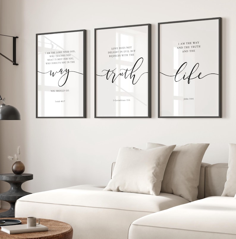 May include: Three framed art prints with black frames and white backgrounds. Each print features elegant black script with inspirational quotes: "way", "truth", and "life". The prints are displayed above a white sofa.