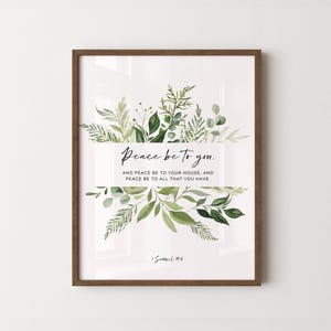 May include: Framed art print with a white background, featuring the text "Peace be to you." and a botanical design of green leaves and foliage. The frame is a warm brown color. The text also includes "And peace be to your house, and peace be to all that you have."