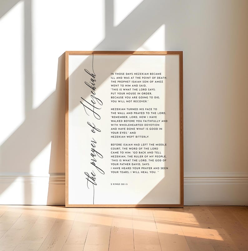 May include: A framed print with the text "the prayer of Hezekiah" in elegant script. The print features a passage from 2 Kings 20:1-5, set against a white background within a wooden frame. The text is in black.