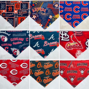 May include: Nine different baseball team themed bandana designs. The bandanas are all triangular and feature a variety of colors and patterns. The teams represented are the Detroit Tigers, Houston Astros, Chicago Cubs, Cleveland Guardians, Atlanta Braves, St. Louis Cardinals, Cincinnati Reds, Baltimore Orioles, and Arizona Diamondbacks.