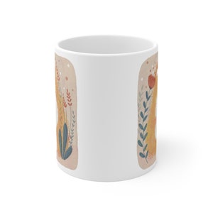 May include: White ceramic mug with a floral design featuring a yellow, orange, and red flower with green leaves on a beige background.