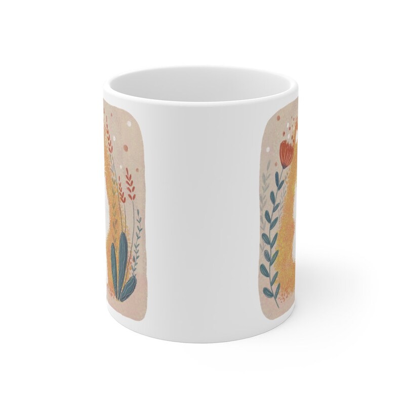 May include: White ceramic mug with a floral design featuring a yellow, orange, and red flower with green leaves on a beige background.
