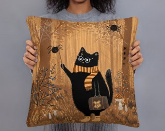 May include: A black cat wearing glasses and a brown and orange scarf holds a wand and a brown suitcase with the Hogwarts crest. The cat is standing in a forest with brown trees, spiderwebs, and mushrooms.