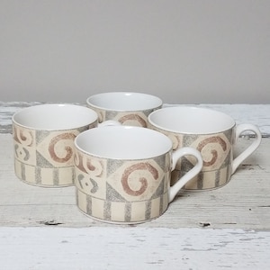 May include: Set of four white ceramic coffee mugs with a geometric pattern in shades of brown and gray.