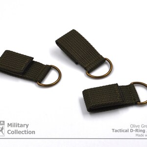Pode incluir: Tr&ecirc;s adaptadores t&aacute;ticos de anel em D de cor verde oliva com an&eacute;is de lat&atilde;o. Olive Green Color Tactical D-Ring Adapter Made with Passion.
