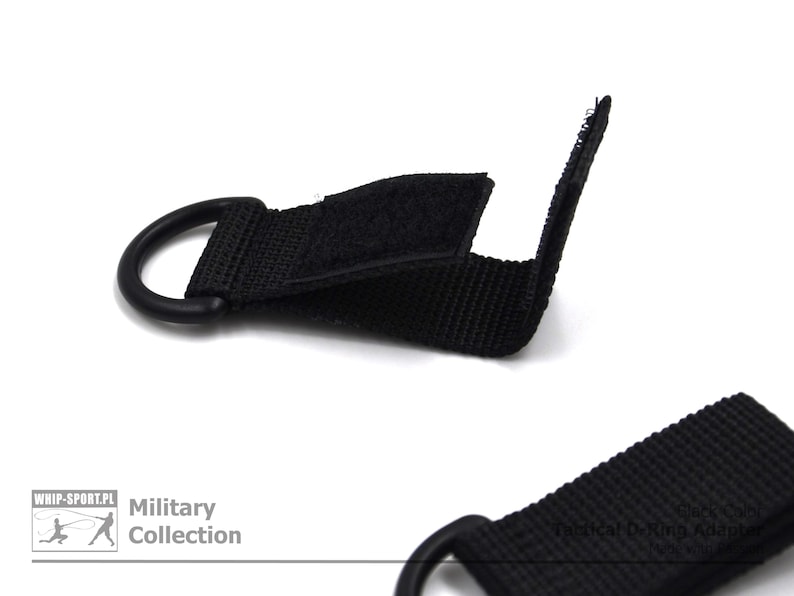 Może przedstawiać: Czarny pasek nylonowy z metalowym pierścieniem i hakiem. Pasek ma zapięcie na rzep, a na pasku nadrukowany jest napis "Military Collection".