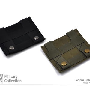 Peut inclure: Deux panneaux de patchs velcro, un noir et un vert, avec des boutons pression en m&eacute;tal. Les panneaux sont con&ccedil;us pour fixer des patchs sur des v&ecirc;tements ou des sacs. Le texte "Military Collection" est imprim&eacute; sous le panneau noir et "Velcro Patch Panel Made with Passion" est imprim&eacute; sous le panneau vert.