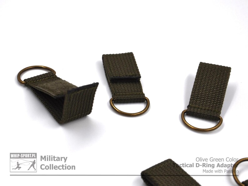Pode incluir: Tr&ecirc;s adaptadores t&aacute;ticos de anel em D de cor verde oliva com an&eacute;is de lat&atilde;o. Os adaptadores s&atilde;o feitos de fita e t&ecirc;m um fecho de velcro. O texto "Olive Green Color Tactical D-Ring Adapter Made with Passion" &eacute; vis&iacute;vel na imagem.