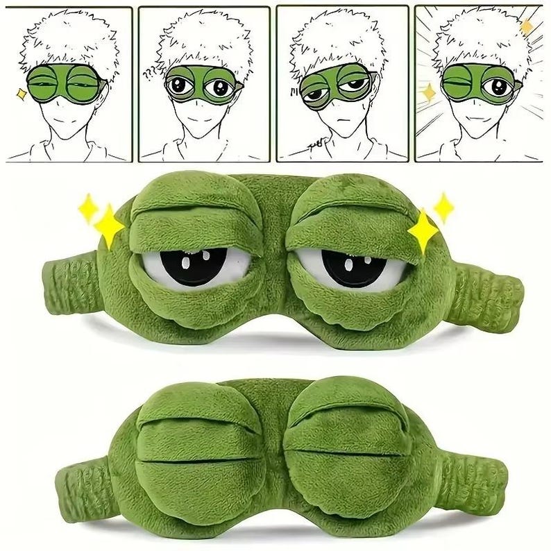Puede incluir: Una m&aacute;scara para dormir de felpa verde con ojos blancos grandes y pupilas negras. La m&aacute;scara tiene la forma de una rana de dibujos animados con una expresi&oacute;n amplia y sonriente. La imagen tambi&eacute;n incluye una tira c&oacute;mica de cuatro paneles.