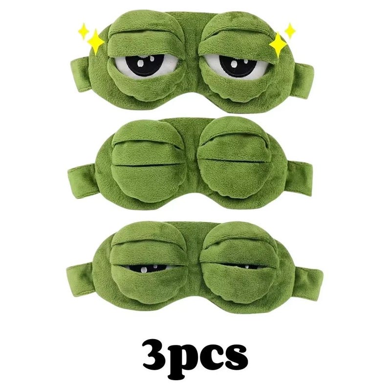 Puede incluir: Tres antifaces verdes con dise&ntilde;o de rana de dibujos animados. Cada antifaz tiene una correa y est&aacute; hecho de material suave. El texto "3pcs" est&aacute; en la parte inferior de la imagen.