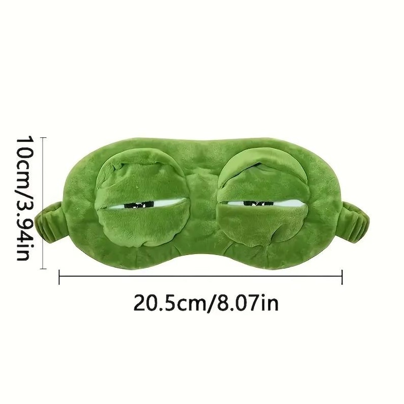 Puede incluir: Una m&aacute;scara para dormir de felpa verde con forma de cara de rana. La m&aacute;scara mide 20,5 cm de largo y 10 cm de alto. Tiene dos ojos grandes y cerrados y est&aacute; dise&ntilde;ada para bloquear la luz para dormir. La m&aacute;scara tiene un aspecto suave y texturizado.