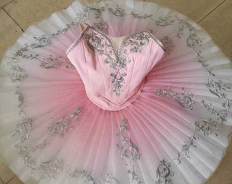 May include: A pink and white ombre tutu with silver embroidery. The tutu has a pink bodice with a sweetheart neckline and silver embroidery.