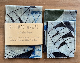 May include: Two sets of beeswax food wraps with a geometric pattern in shades of blue, black, and green. The wraps are made by Blue Tansy Treasures and have the quote "We do not inherit the Earth from our ancestors, we borrow it from our children" -W. Berry.