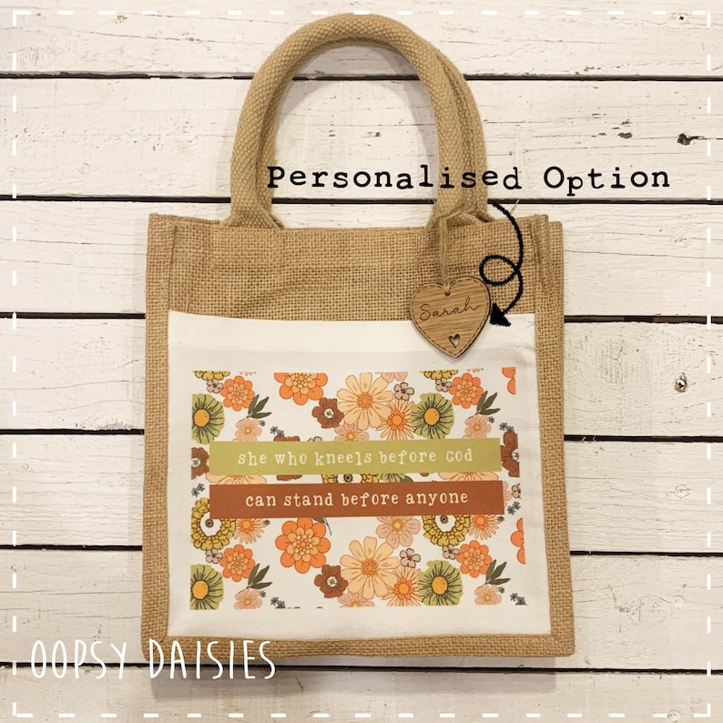 Pode incluir: Uma bolsa de juta personalizada com um design floral e a cita&ccedil;&atilde;o "Ela que se ajoelha diante de Deus pode ficar de p&eacute; diante de qualquer um". A bolsa tem um amuleto de cora&ccedil;&atilde;o de madeira com o nome "Sarah" nele. A bolsa &eacute; um &oacute;timo presente para uma ocasi&atilde;o especial.