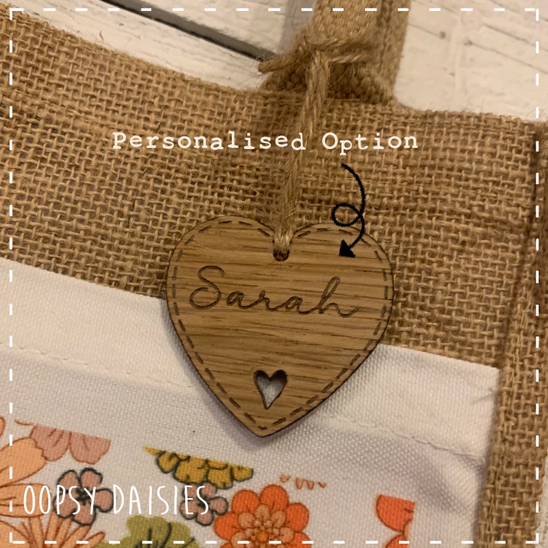 Pode incluir: Uma bolsa de juta com uma etiqueta de cora&ccedil;&atilde;o de madeira personalizada que diz "Sarah". A etiqueta &eacute; presa &agrave; bolsa com um barbante.