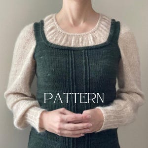 Puede incluir: Un suéter de punto verde con una capa superior de punto crema. El suéter tiene un escote cuadrado y la capa superior tiene un escote redondo. El texto "PATTERN" está impreso en la parte delantera del suéter.