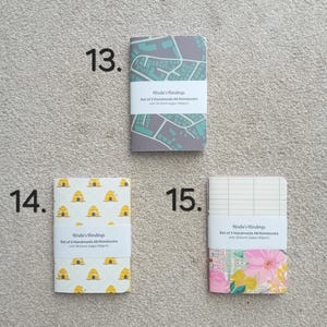 May include: Set of two A6 notebooks with 30 blank pages. The notebooks have different designs: a city map, a beehive pattern, and a floral pattern. Each notebook has the text "Birdie's Bindings" printed on the cover.