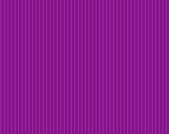 May include: Close-up of a fabric with vertical stripes. The fabric features alternating stripes of deep purple and a thinner, lighter pink. The ruler at the bottom shows measurements in inches. The text "Free Spirit" and "freespiritfabrics.com" are visible.