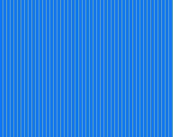 May include: Blue fabric with vertical stripes. The stripes are a lighter blue color and are evenly spaced. The fabric has a ruler along the bottom edge with measurements in inches. The text "Free Spirit" and "freespiritfabrics.com" are visible.