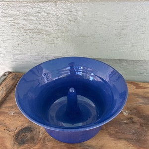 May include: A blue ceramic apple baker with a central ring for baking a whole apple.