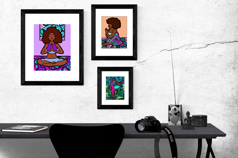 May include: Three framed illustrations of women in different yoga poses. The illustrations are colorful and feature a black background. The frames are black and have a white mat.