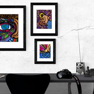 May include: Three framed illustrations with black frames and white mats. The illustrations are colorful and abstract. The top left illustration features a large eye with a world inside. The top right illustration features a couple embracing. The bottom illustration features a foot with a colorful design.