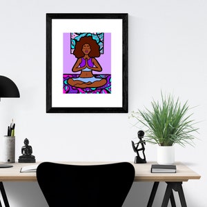 May include: A framed illustration of a woman with dark brown skin meditating in a lotus pose. She is wearing a purple top and blue pants. The background is a purple and blue patterned design.
