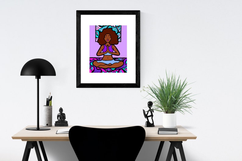 May include: A framed illustration of a woman with dark brown skin meditating in a lotus pose. She is wearing a purple top and blue pants. The background is a purple and blue patterned design.