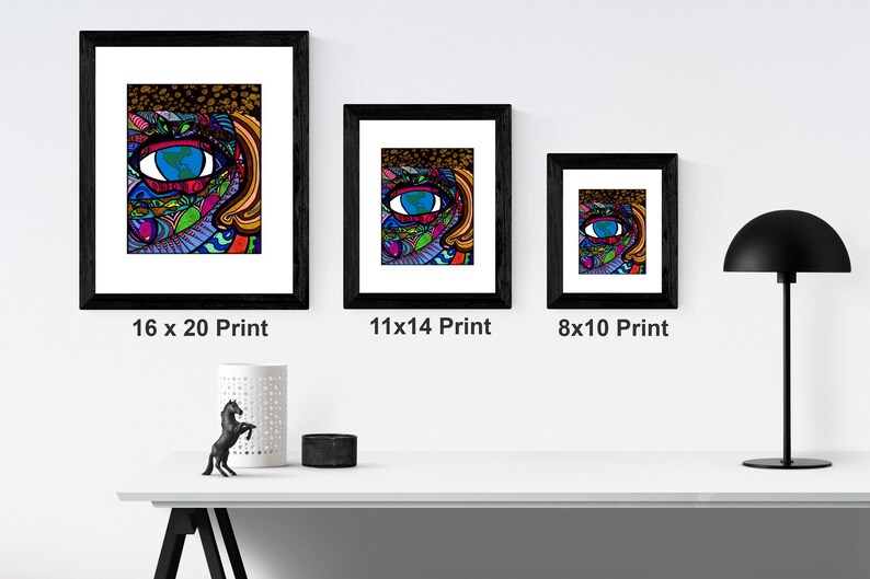 May include: Three framed prints of a colorful, abstract illustration of an eye with a globe inside. The prints are in black frames and are displayed on a white wall. The prints are labeled with their sizes: 16 x 20, 11 x 14, and 8 x 10.