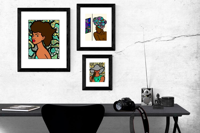 May include: Three framed illustrations of women with different hairstyles and headwear. The illustrations are in a black frame and are hung on a white wall. The illustrations are in a colorful cartoon style.