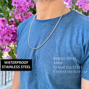 May include: A silver chain necklace made of stainless steel. The chain is 4mm wide and is waterproof. The text "WATERPROOF STAINLESS STEEL" and "BIRCH+STEEL 4MM STAINLESS STEEL CHOOSE FROM 13" - 24" is visible in the image.