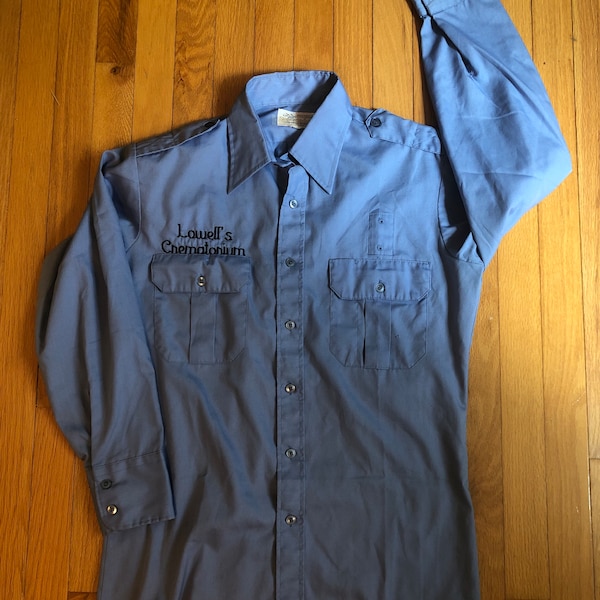 Blue Work Shirt reads “Lowell’s Crematorium”