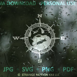 May include: A compass with a white outline and a gray interior, featuring a stylized map of a mountain range. The compass is set against a dark background with water droplets.