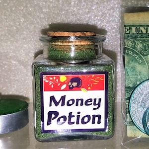 May include: A small glass jar with a cork lid filled with green glitter. The jar has a label that says "Money Potion" with a skull and crossbones graphic.