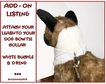 May include: White dog bowtie collar with a white buckle and a metal D-ring. The collar is attached to a leash. The text on the image reads: "ADD-ON LISTING ATTACH YOUR LEASHTO YOUR DOG BOWTIE COLLAR WHITE BUCKLE & DRING *** SMILEAWHILEPETS"