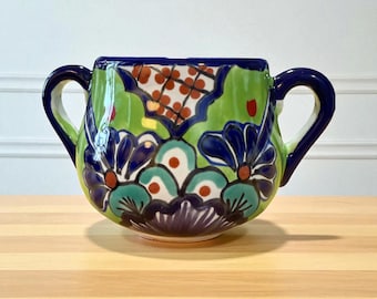 Bol de cerámica mexicana estilo Talavera con doble asa, pintado a mano, sin plomo, ideal para decorar la cocina con un toque de arte popular.