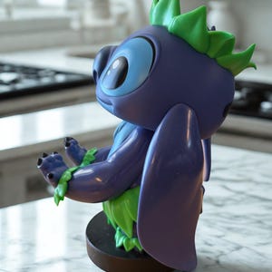 Puede incluir: Una figura del personaje Stitch de la pel&iacute;cula animada Lilo & Stitch. La figura es principalmente morada con grandes ojos azules, detalles verdes y una base marr&oacute;n. Est&aacute; posando con los brazos extendidos.