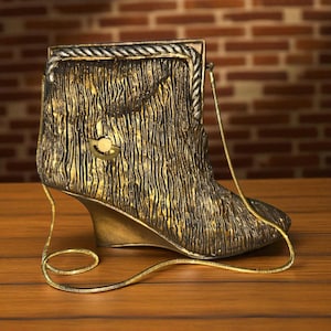 May include: A decorative boot-shaped purse with a gold and black textured finish. The purse features a wedge heel and a gold chain strap. The top edge is framed with a rope-like design. The purse is displayed on a wooden surface.