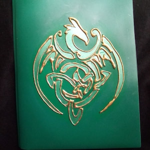 May include: A green folder with a gold embossed dragon design. The dragon is curled up with its wings spread out.